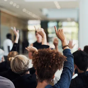 Behind shot of a group of people raising their hands